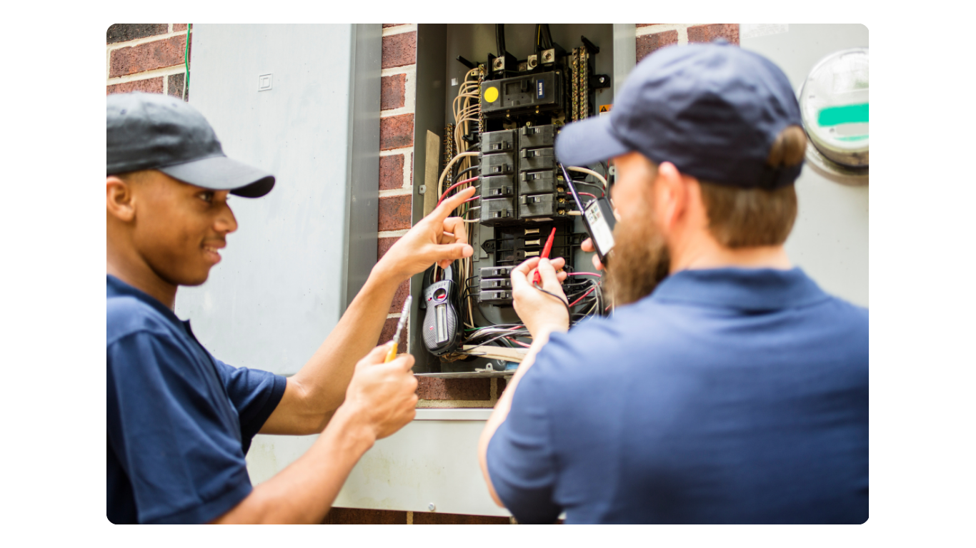 Electricians working on electric panel Electricians working on electric panel