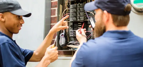 Electricians working on electric panel